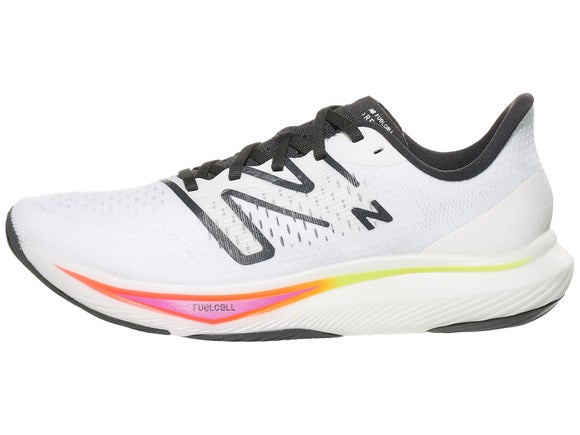 New Balance FuelCell Rebel v3 running shoe. Upper is white with black New Balance logo and the midsole is white with yellow and orange features. 