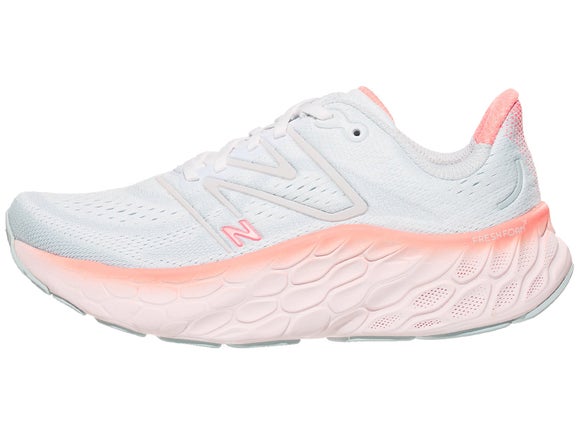 New Balance More v4 Running shoe. Upper is white with silver New Balance logo and the midsole is white with hits of peach and pink as a border at the top of the midsole foam.
